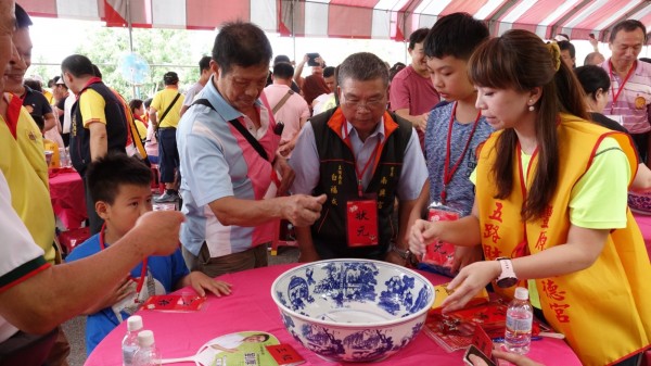 豐原區武德宮五路財神廟舉辦博餅狀元王活動，民眾聚精會神擲骰子。（武德宮提供）