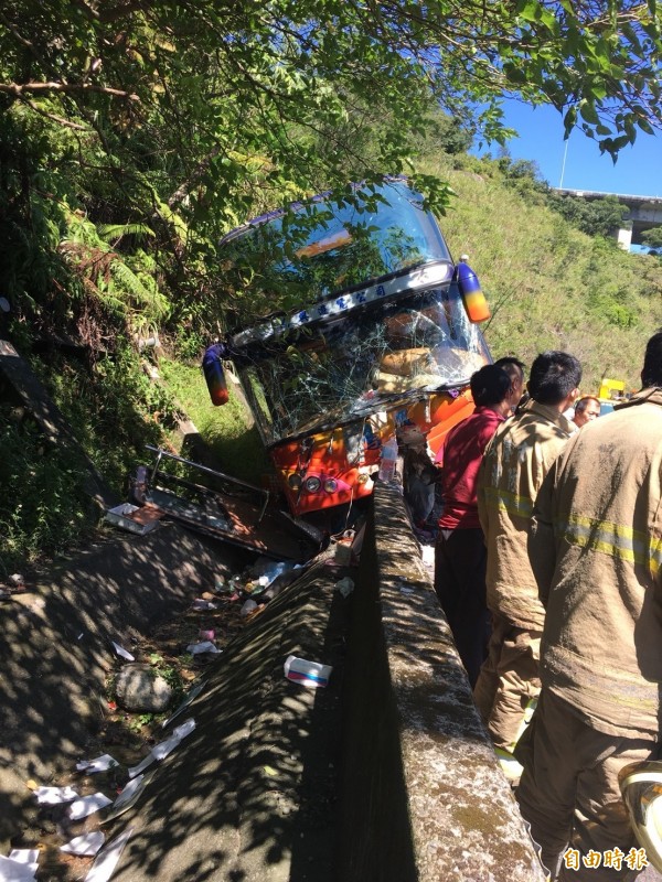 遊覽車騎上水泥護欄。（記者吳昇儒攝）