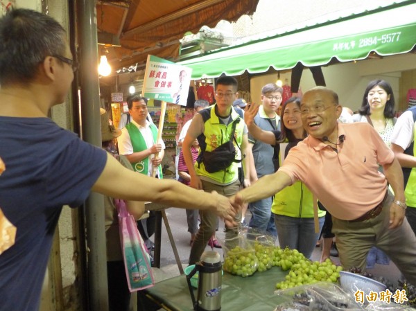 民進黨新北市長參選人蘇貞昌和地方議員參選人，在淡水區清水市場和攤商打招呼。（記者李雅雯攝）