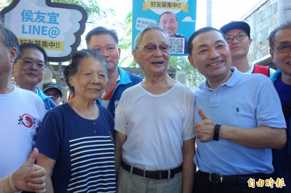 國民黨新北市長參選人侯友宜今早到新莊運動公園拜票，遇到一名109歲的宋姓人瑞（白衣者），眾人驚呼人瑞身體超健朗。（記者葉冠妤攝）