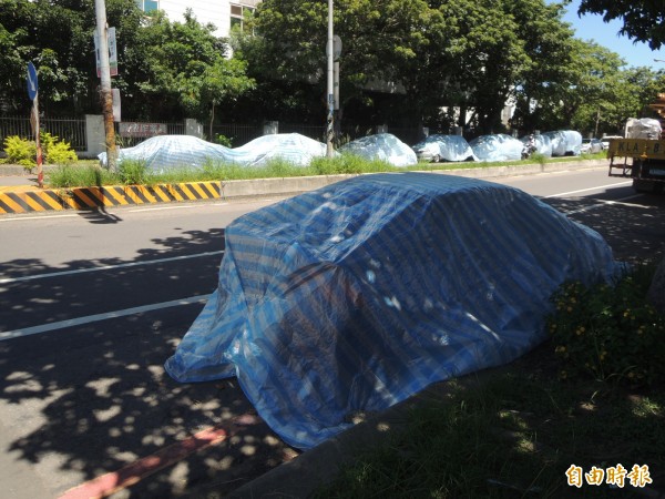 新竹工業區光復路兩側路邊停滿了車子，部分車輛甚至覆蓋帆布長期停放，讓用路人傻眼。（記者廖雪茹攝）