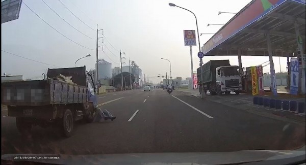 一輛貨車行駛在內線車道，經過加油站時，一名男子突然從路旁衝出，看到了貨車就「匍匐臥地」，疑似想製造假車禍，幸貨車及時煞停。（翻攝自爆料公社）