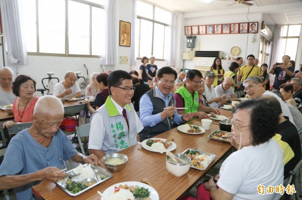 沙鹿洛泉社區關懷社區長輩供餐，市長林佳龍（左三）與民眾同樂。（記者張軒哲攝）