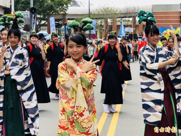 香川高松西高等學校表演盆栽體操舞，輕快的節奏與可愛的舞蹈，吸引路過遊客圍觀。（記者許倬勛攝）