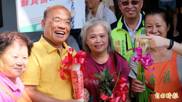 民進黨新北市長參選人蘇貞昌今天一早到瑞芳市場掃街拜票，獲得攤商和民眾的熱情歡迎，送上蔥 、蒜、蘿蔔給他，祝他高票當選。（記者林欣漢攝）