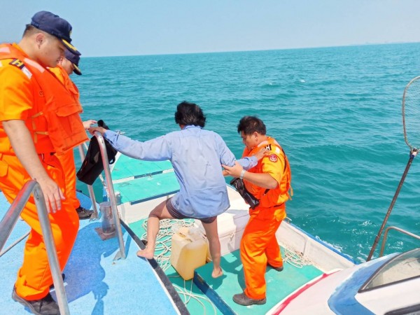 海巡隊員將落海獲救的漁船蘇姓船長（右二）接駁到巡防艇上照料。（記者王俊忠翻攝）