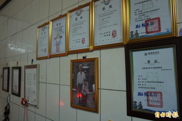 卓女將兒女參賽得獎的獎狀掛在牆上。（記者林宜樟攝）