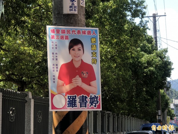 鎮民代表參選人羅書婷的競選看板，被張姓婦人拆下當成烤肉用的煽風工具。（記者佟振國攝）