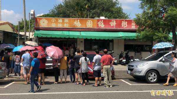 中午豔陽高照，十分悶熱，但梅園餡餅粥外還是大排長龍。（記者佟振國攝）