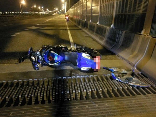 張姓女騎士行經台64線快速道路五股路段,疑似過彎時車速過快,擦撞護欄後自摔,重機遺留現場。(記者曾健銘翻攝)