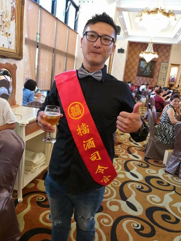 南投縣婚宴出現「擋酒司令官」,披紅綵帶幫新人擋酒。(陳國大提供)
