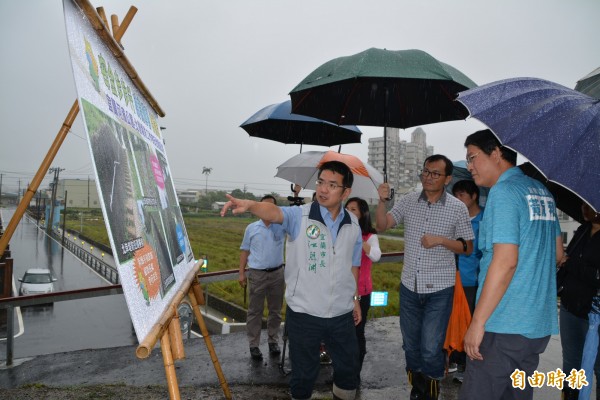 宜蘭市長江聰淵(左)等人,今天冒雨會勘宜蘭河濱公園工作梯扶手設置情形。(記者游明金攝)