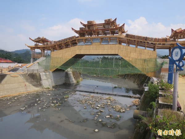 集集鎮武昌宮旁正在興建的中國廊橋即將完工,惟橋下卻是污濁水流,景象形成強烈對比。(記者劉濱銓攝)