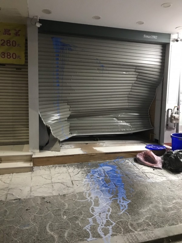 嘉義市東區大雅路知名連鎖飲料店先遭潑漆再被撞凹鐵門。(讀者提供)
