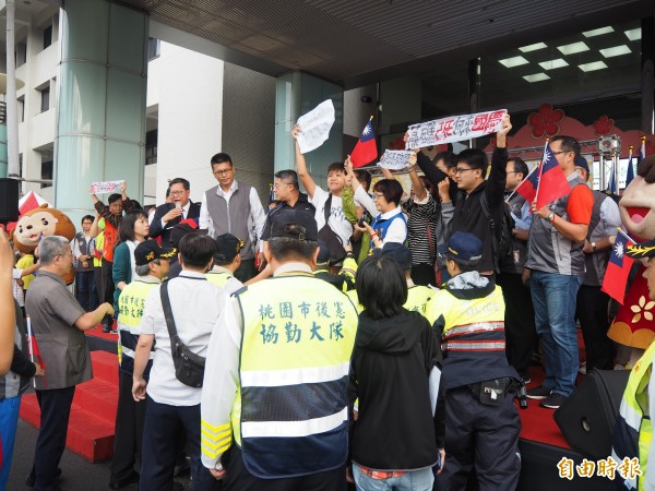 桃園市政府今天首次自辦升旗典禮,市長鄭文燦致詞時,市長參選人朱梅雪突然率人衝上台抗議。(記者陳昀攝)