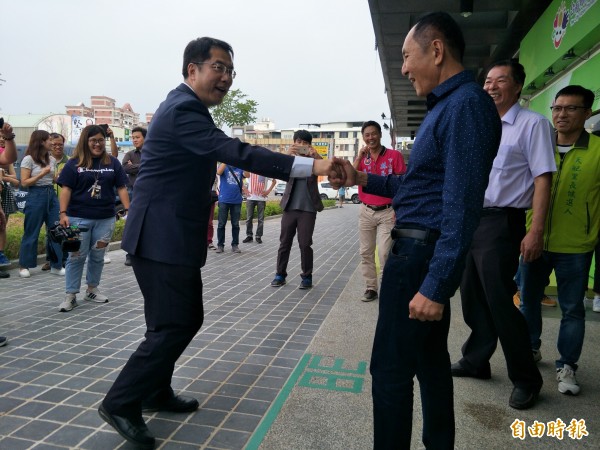 林義豐在進入城市願景館時,2人互跨「38度線」。(記者邱灝唐攝)