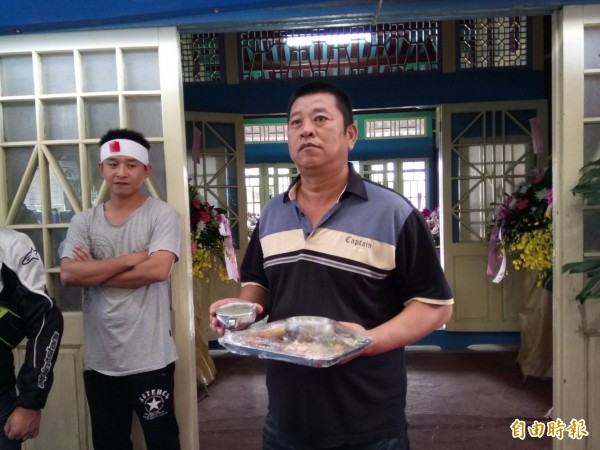 元長西莊社區發展協會前總幹事蔡啟暉為「茂男伯」送來出殯前最後一盤飯菜。(記者廖淑玲攝)