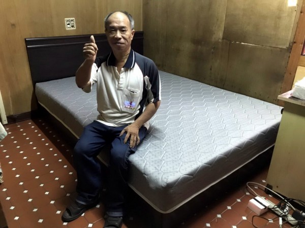 台電台南區營業處訂製床架及床墊,讓李同學不用再打地舖睡覺,家長比起大拇指稱讚。(南台南家扶中心提供)
