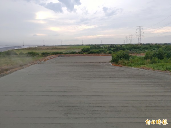 竹塘鄉公所災損勘查人員莊啟祐扮千里眼,從自強大橋下勘災。(記者陳冠備攝)