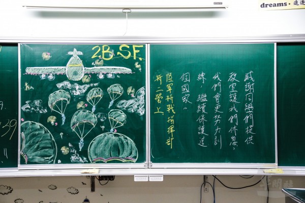 胡羽震以C-130運輸機配合朵朵傘花的畫作,向同學們致意。(圖由軍聞社提供)