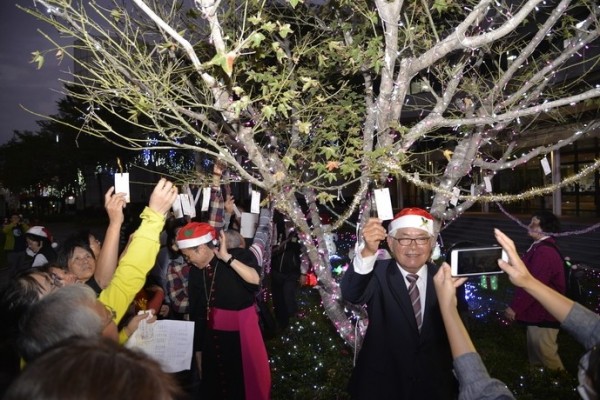 雲林縣長李進勇將寫好祝福與願望的祈福卡高掛樹上。(雲林縣政府提供)