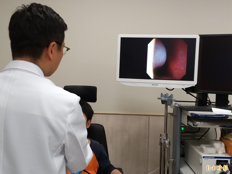 中醫大新竹附醫耳鼻喉科主任王堂權為王小弟檢查術後耳鼻功能恢復狀況。(記者廖雪茹攝) 中醫大新竹附醫耳鼻喉科主任王堂權為王小弟檢查術後耳鼻功能恢復狀況。(記者廖雪茹攝)