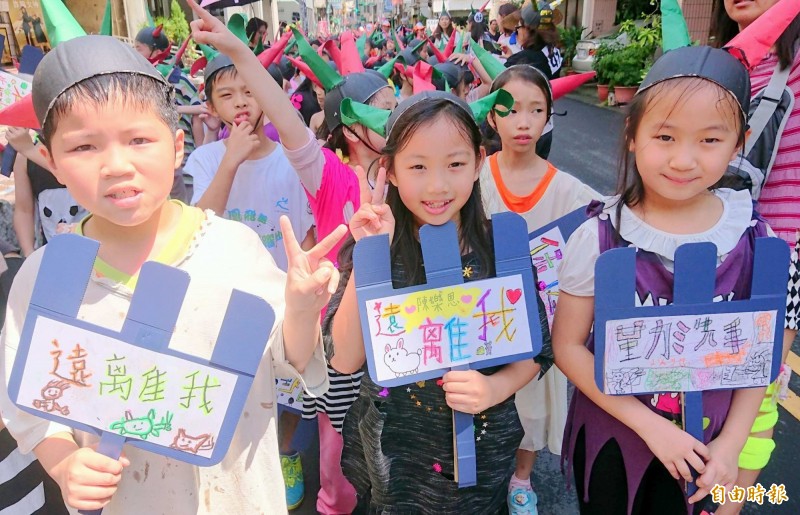 南投縣衛生局進行腸病毒防治宣導,小朋友高舉「腸病毒遠離我」等標語。(記者謝介裕攝)