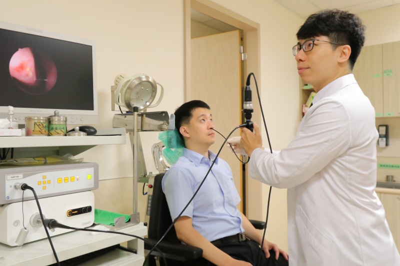 亞大醫院耳鼻喉部主治醫師許哲綸(右)以鼻咽內視鏡替患者檢查鼻腔,建議有打鼾困擾民眾,可考慮接受「溫控式無線射頻打鼾手術」治療。圖為情境照,圖中人物與本文無關。(記者陳建志攝)