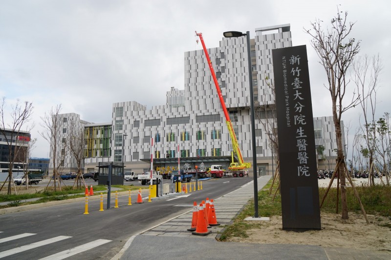 台大醫院新竹生醫園區分院即將在16日開幕、17日營運,今天正在施作招牌金字吊掛固定工程。(新竹縣政府提供)