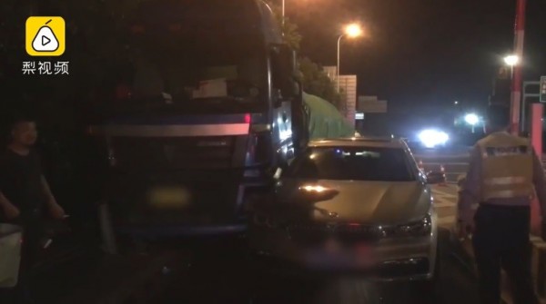 一名驾驶在开车进收费站时,因为贪快而突然改变车道,结果发生擦撞,被夹在大卡车与收费站护栏间。(图撷取自梨视频)