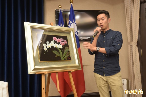 蝴蝶蘭漆畫創作人王峻偉說明創作緣由。(記者張嘉明攝)