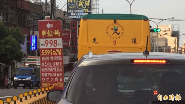 新竹縣警方表示,如圖違規繫掛在中央分隔島兩端的大型廣告看板有妨害行車視線衍生事故的疑慮。(記者黃美珠攝)