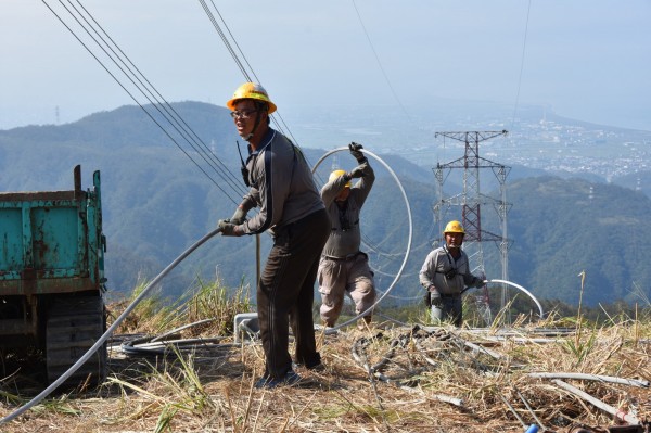 搶修和平電廠電塔,電塔間的導體重量相當重,維修人員必須先延放直徑約與原子筆芯一樣細的較輕引線開始,再牽引細尼龍線、粗尼龍線、鋼絲,逐步作業,最後才以鋼絲牽引真正的纜線。(經濟部提供)