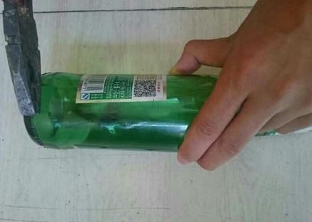 男學生以鉗子從酒瓶敲下較厚的底部玻璃。（圖擷自《成都商報》）