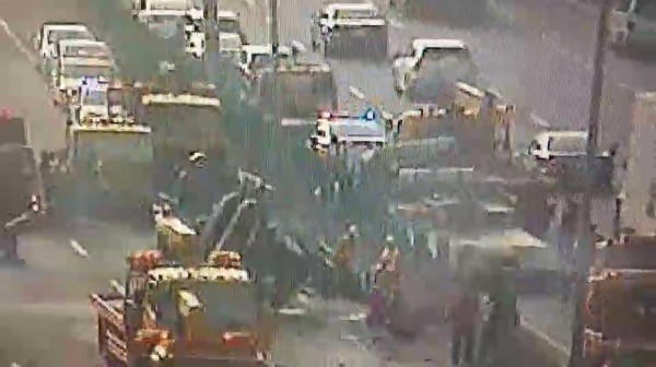 半聯結車疑似左前輪爆胎,導致車輛失控撞內側護欄,車上載運的2部挖土機,飛越中央分隔島,掉落在南下車道。(警方提供)