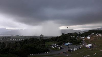 1群遊客從鹿野高台拍下遠方雨瀑奇觀,烏雲密布的天空中宛如破洞般降下傾盆大雨,但僅有局部地區受大雨影響。(圖擷取自爆料公社)