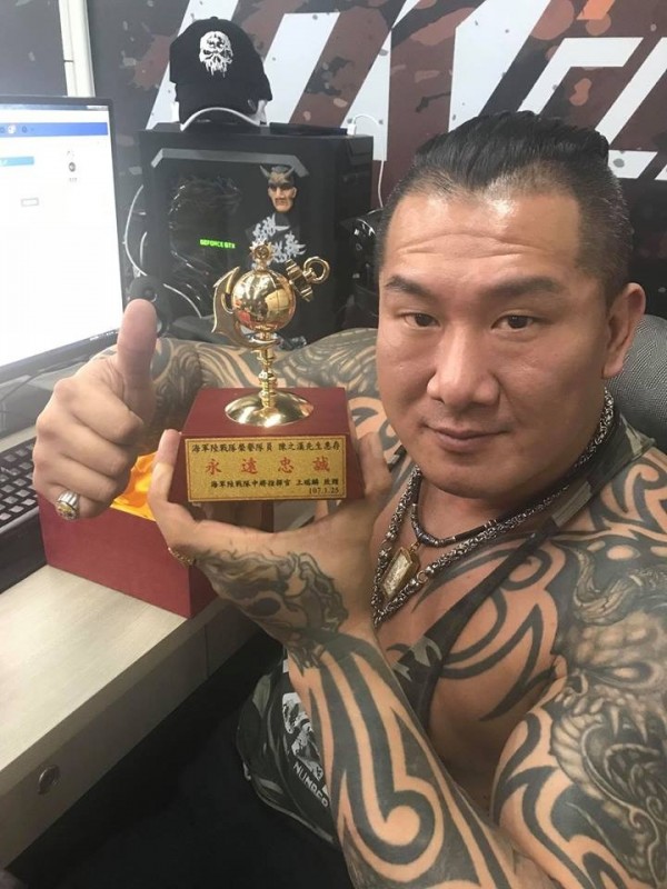 館長開心的舉起海軍陸戰隊榮譽隊員的獎座。（圖擷自「飆捍」臉書）