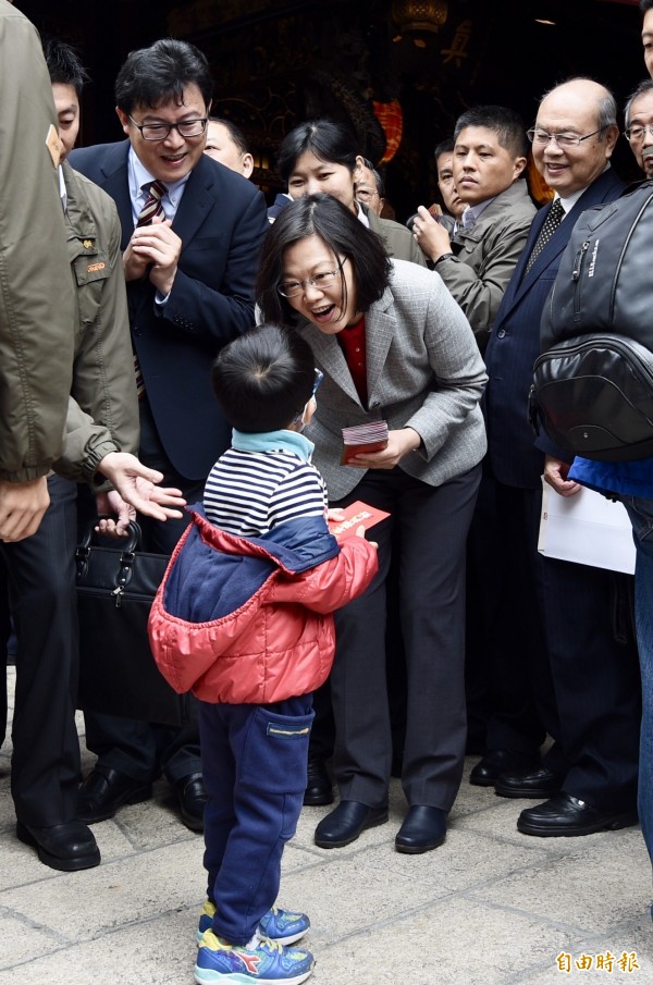 總統蔡英文、民進黨立委姚文智（左1）17日至台北保安宮發送紅包，向民眾拜年，保安宮董事長廖武治（右1）陪同。（記者羅沛德攝）