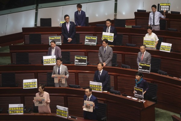 泛民派議員們在林鄭月娥要上台報告前,全體起立並高舉「捍衛新聞自由」、「停止打壓記者」等標語,呼喊著口號抗議。(美聯社)