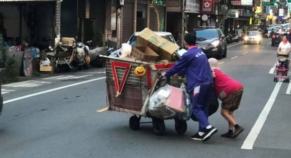 穿著高中運動服的男學生，幫忙一名車上滿載回收物的老阿婆過馬路。（圖擷自臉書社團《爆料公社》）