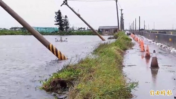 雲林縣沿海魚塭塭堤崩塌嚴重，連電線桿都滑落魚塭。（記者廖淑玲攝）