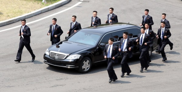文金會中午分開用膳，金正恩搭乘座車暫時回到北韓，隨扈圍著車輛行進。（歐新社）
