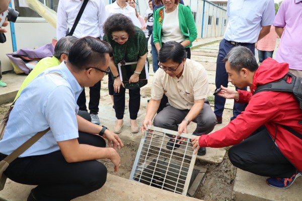 高雄旗山國中在組合屋教室外新增地下排水孔，部長葉俊榮親自打開觀察施工情形。（高雄市教育局提供）