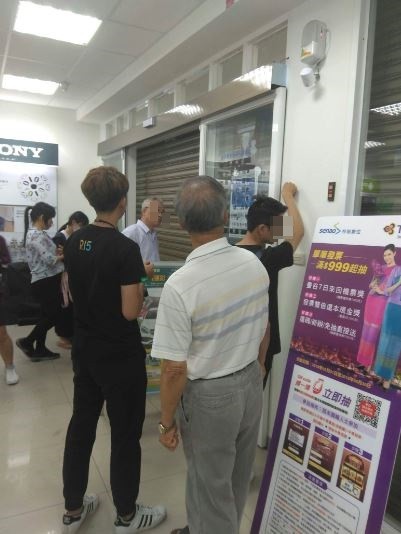 門市鐵門在一陣開開關關後,馬達也跟著燒壞,導至門市人員和民眾「合宿」在店內一小時。(圖擷取自Dcard)