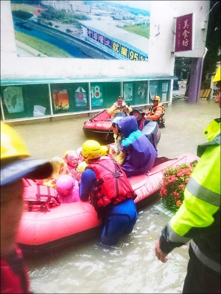 暴雨襲擊南台灣，台南仁德中華醫事科技大學校內一片汪洋，南市消防局獲報派遣兩部橡皮艇協助救援，幼兒園孩童一個接一個搭上船艇撤離。（記者萬于甄翻攝）