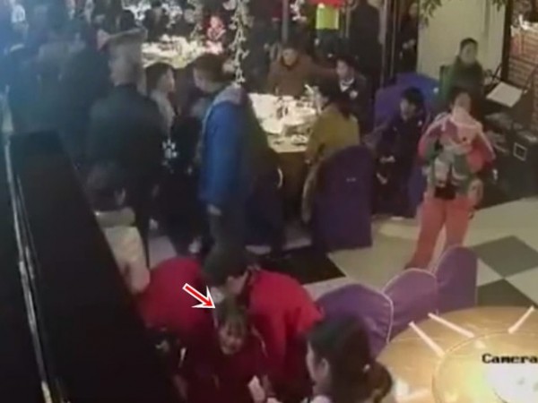 女服務生(箭頭處)被打到倒地。(圖擷自網路)