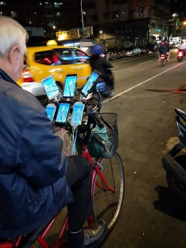 阿伯在腳踏車上裝了6支手機同時抓寶,被外國人封為「鐵血玩家」。(圖擷取自爆廢公社)
