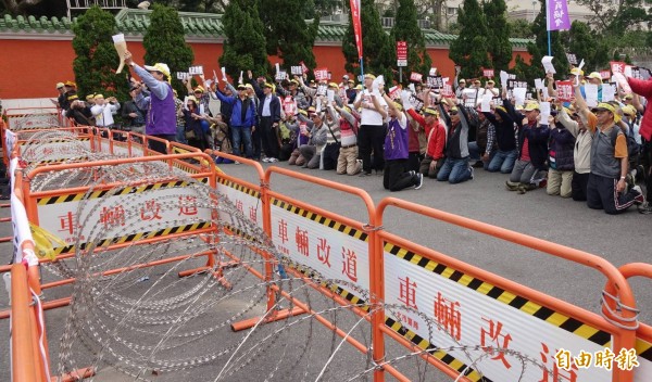 超過200名退休警消人員在忠烈祠聚集,抗議蔡英文政府推動年金改革,並在總統車隊經過時下跪陳情抗議。(記者劉信德攝)