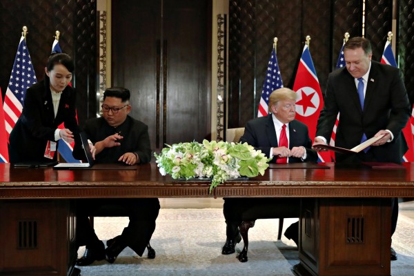 金正恩與川普昨下午共同簽署文件時,金與正在一旁協助,並遞上金正恩專用的鋼筆。(路透)