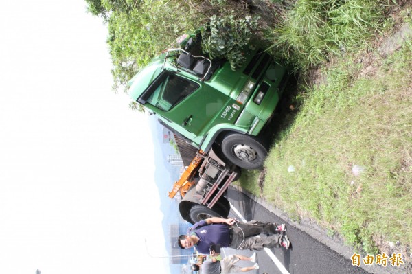 貨櫃車頭滑進交流道旁邊坡。（記者吳昇儒攝）